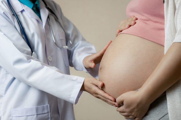 Happy pregnant woman visit gynecologist doctor at hospital or clinic for pregnancy consultant.